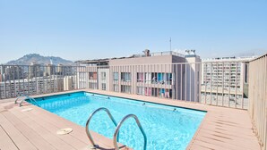 A rooftop swimming pool with a view of a cityscape and a hill in the background. - "Live life to the fullest in the heart of Santiago"! (Santiago)