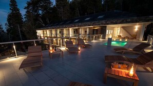 Una casa moderna con piscina, mobiliario exterior y una escalera que lleva al piso superior.