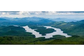 Surrounded by dense forested hills, this serene landscape features interconnected lakes of varying sizes.