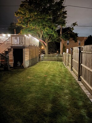 Backyard oasis with a shaded area, staircase, and brick structure.