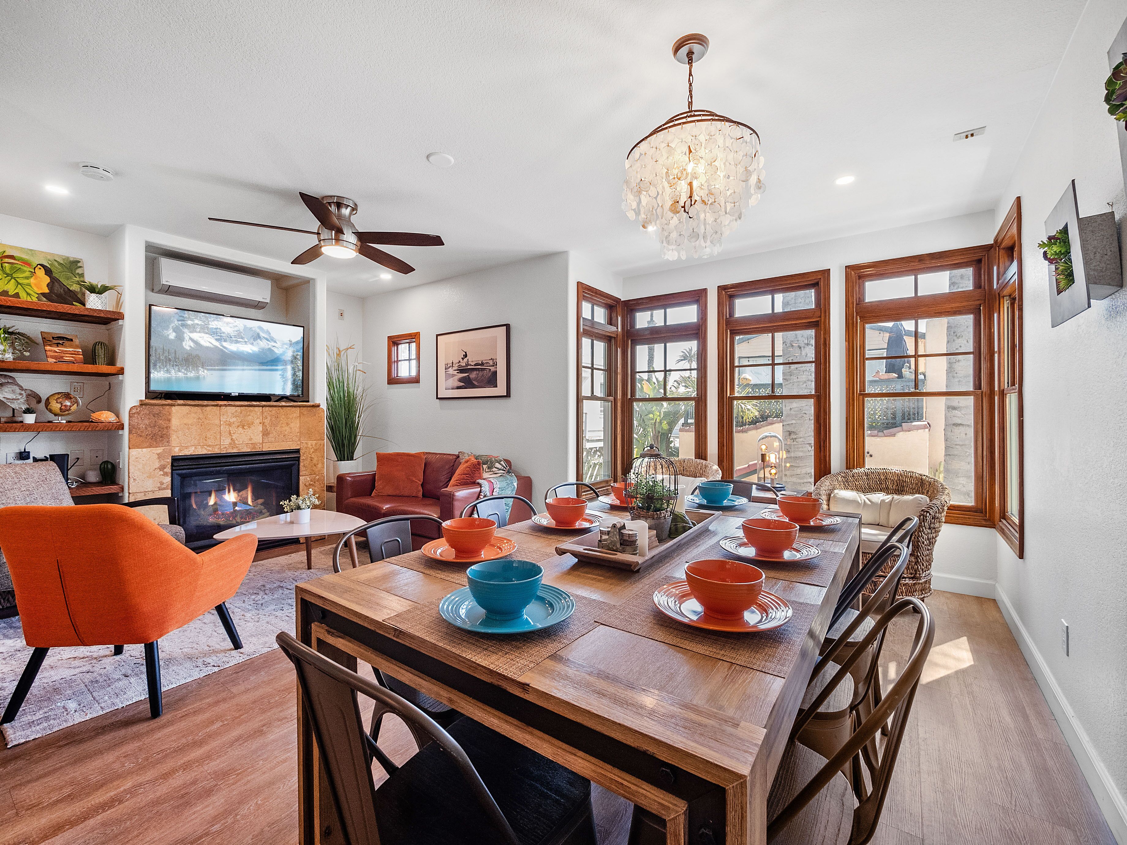 A dining area with a wooden table, orange chairs, and a chandelier.
