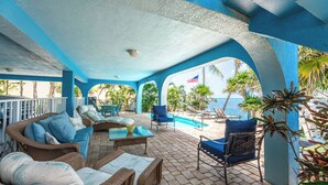 A covered outdoor area with wicker furniture, a pool, and a view of the ocean. - Waterfront Oasis - 3/2 w/ Heated Pool & Direct Ocean Views (Marathon)