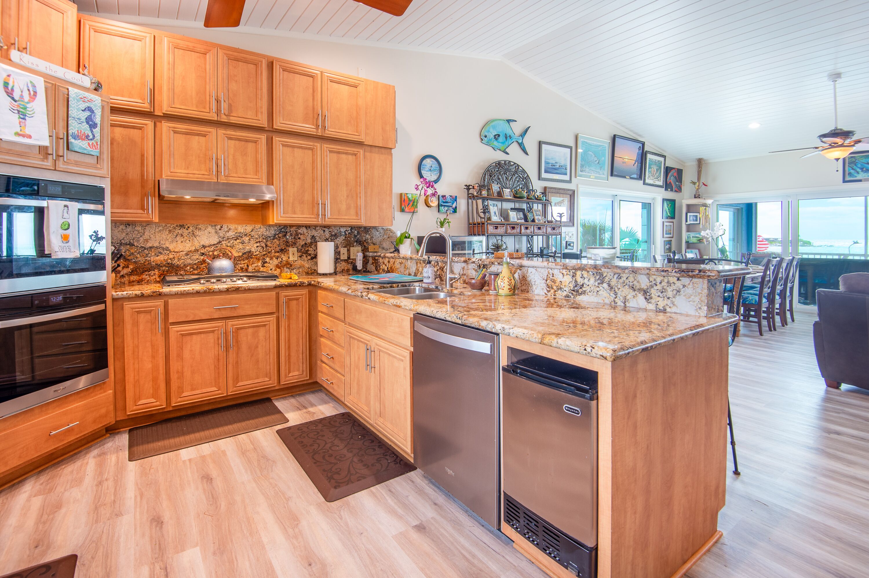A spacious kitchen with wooden cabinets, granite countertops, stainless steel appliances, and a large island.