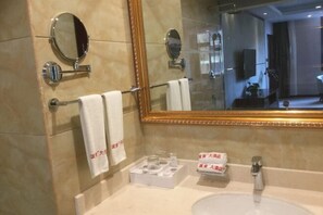 Bathroom features a large mirror, two additional mirrors above the sink, and a towel rack with two towels.