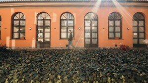 Un edificio con ventanas arqueadas y un camino de ladrillo.