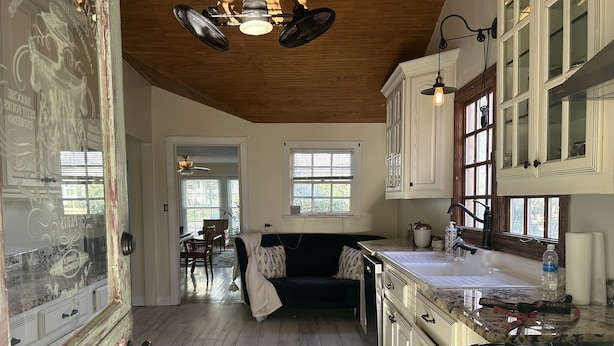 Une cuisine spacieuse avec un plancher en bois, un coin repas avec une table et des chaises, et un coin salon confortable avec un canapé.