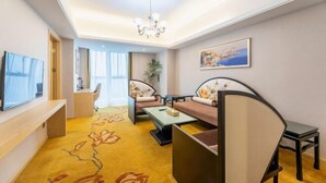 A modern living room with a sofa, chairs, a coffee table, and a TV. - Vienna International Hotel (Changsha Orange Isle Head) (Changsha)