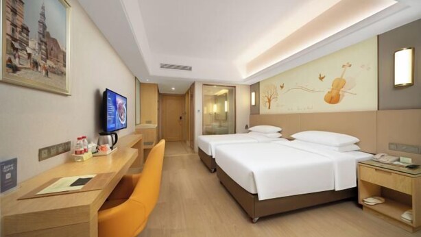 A hotel room with a desk, two beds, a TV, and artwork on the walls. - Vienna International Hotel (Changsha Orange Isle Head) (Changsha)