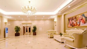 A spacious lobby with a chandelier, plush sofas, and a large painting on the wall. - Vienna International Hotel (Changsha Orange Isle Head) (Changsha)
