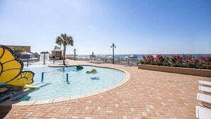 En swimmingpool med buet kant, en palme og frit udsyn til havet.