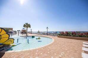 Una piscina de borde curvo, una palmera y una vista despejada del océano.