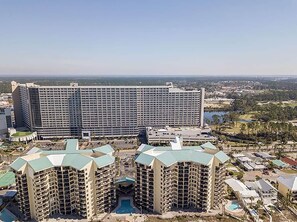 Un hotel moderno de gran altura con varios pisos, un patio central y vistas del paisaje circundante.