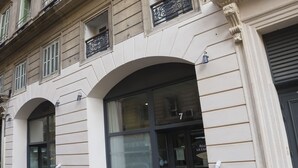 Fachada de edificio con ventanas arqueadas y una puerta marcada con el número 7.