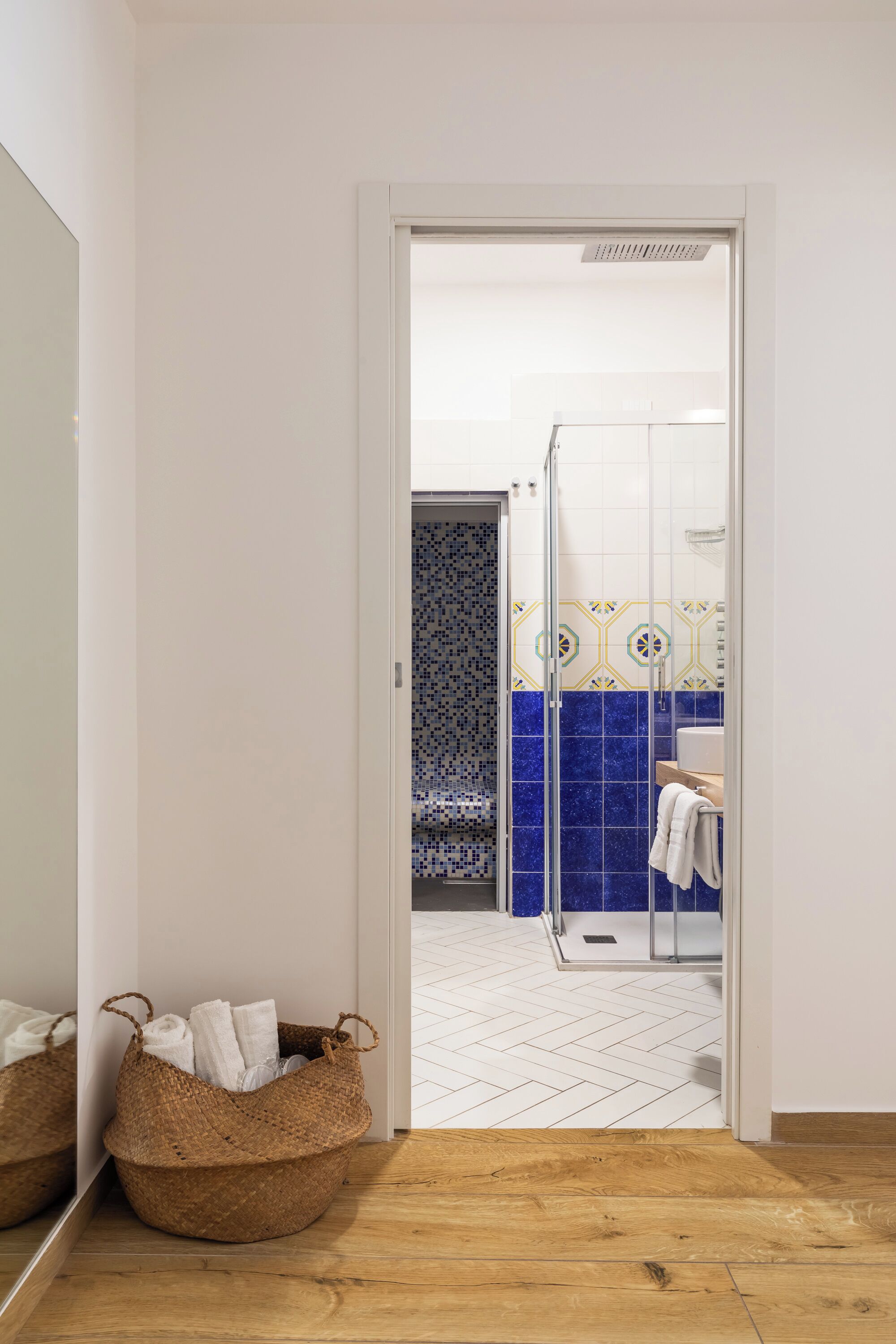 Een badkamer met een douche, een betegelde muur en een witte vloer.
