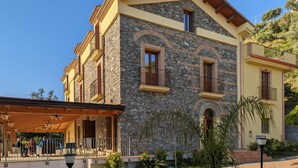 A stone building with multiple balconies and a covered outdoor seating area.