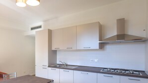 A modern kitchen with white cabinets, a gas stove, and a built-in oven.