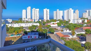 A high-rise residential area with multiple white buildings, some with balconies, and a clear view of the ocean. - Apartamentos Velas al Mar Rodadero (Santa Marta)