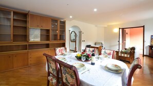 A dining area with a round table set for four, surrounded by floral-patterned chairs.