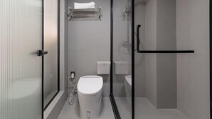 Une salle de bain moderne avec une douche à parois de verre, des toilettes et un porte-serviettes.