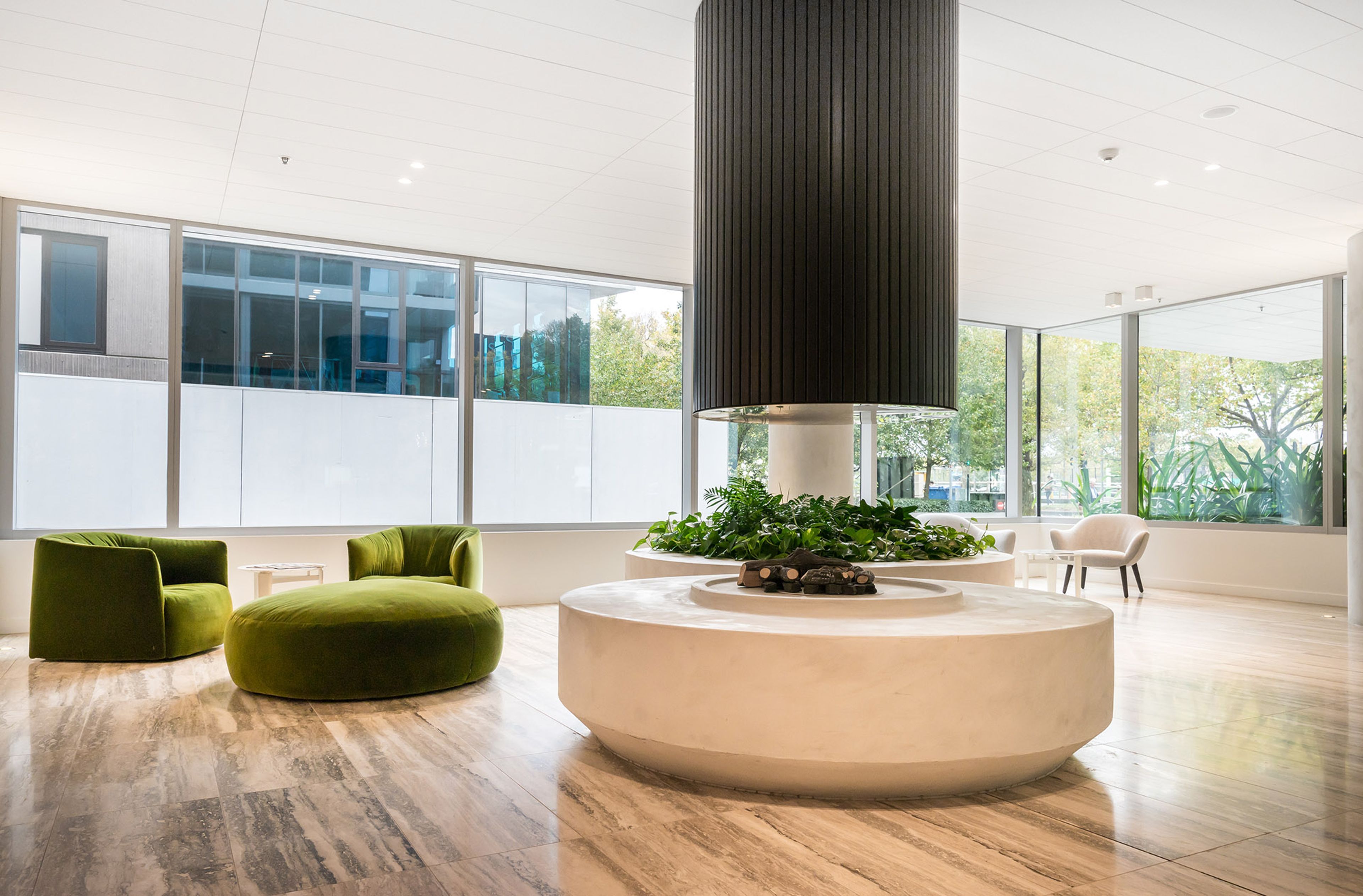 Ein modernes Interieur mit einer runden Sitzecke, großen Fenstern und einer zentralen Säule.