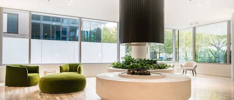 Ein modernes Interieur mit einer runden Sitzecke, großen Fenstern und einer zentralen Säule.