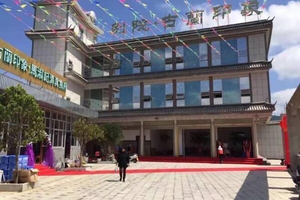 A building with a red carpet entrance, a large glass facade, and a sign indicating it is a hotel.
