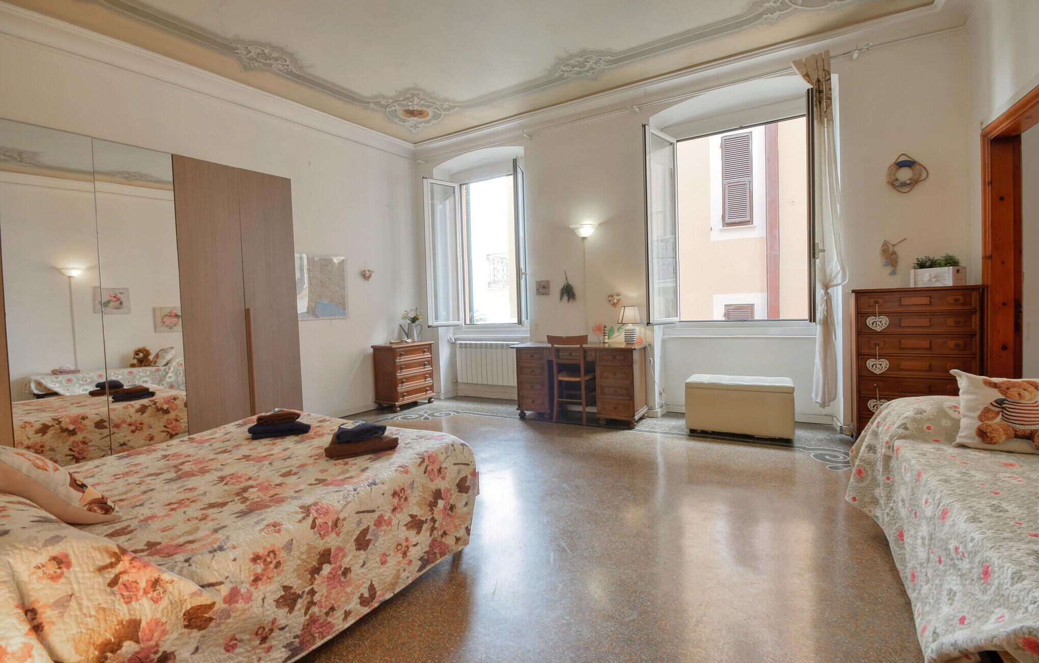 Ein Schlafzimmer mit zwei Betten, einem Schreibtisch und einer Kommode.