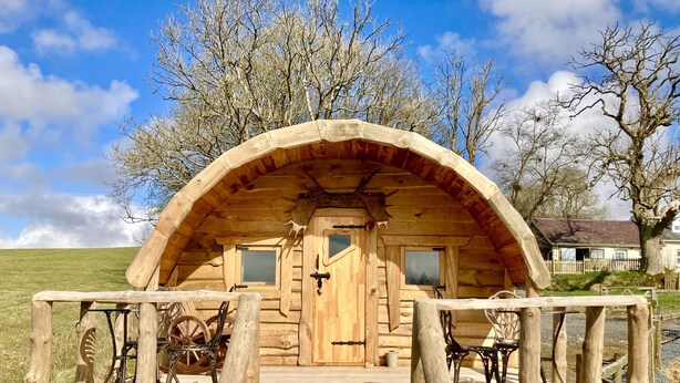 Une cabane en bois avec une véranda, deux fenêtres et une porte.