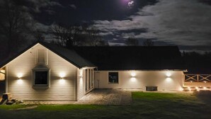 A two-story house with a sloped roof, a chimney, and a porch with lights. - 1 bedroom cozy home in Gislaved (Gislaved)