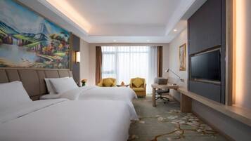 A hotel room with two beds, a desk, a chair, a television, and a large painting on the wall.