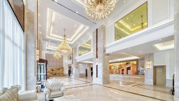 A spacious lobby with high ceilings, elegant chandeliers, and plush seating areas.