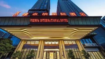 Un hotel con una entrada destacada, amplias ventanas y un cartel que indica que es el Vienna International Hotel.