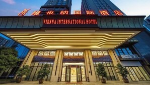 Vienna International Hotel with a modern facade, large entrance, and illuminated signage.