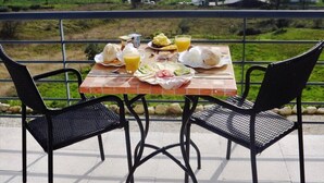 A table with breakfast items and a scenic view of a vineyard. - Casa Ceedina Bed and Breakfast & Beauty (Batalha)