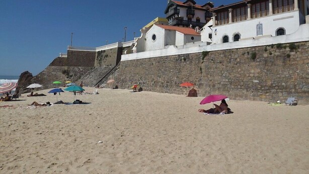 A beach with a stone wall and buildings in the background. - Casa Ceedina Bed and Breakfast & Beauty (Batalha)