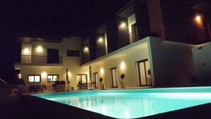 A modern two-story house with a swimming pool at night. - Casa Ceedina Bed and Breakfast & Beauty (Batalha)
