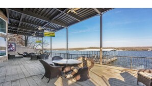 Une terrasse extérieure avec des sièges et une vue sur l’eau.