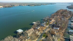 Vue aérienne d’un quartier résidentiel au bord d’un lac, avec des maisons et des quais.