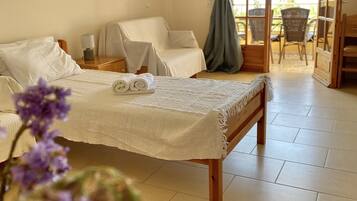 Une chambre avec un lit, une chaise, une table et un balcon offrant une vue.