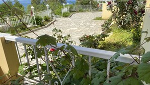 A stone pathway leading to a white fence with a view of the sea. - Armonia - Elegant Apartments (Mantoudi-Limni-Agia Anna)