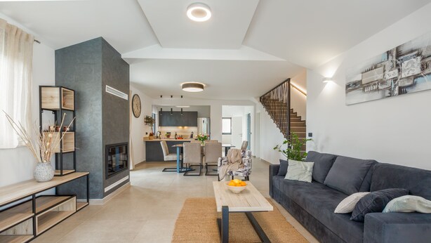 A modern living room with a sofa, coffee table, and a staircase leading to a kitchen. - Villa for 4-6 people, pool, loungers, garden, panoramic sea view (Poreč)