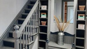 A staircase with a wooden handrail and a gray wall.