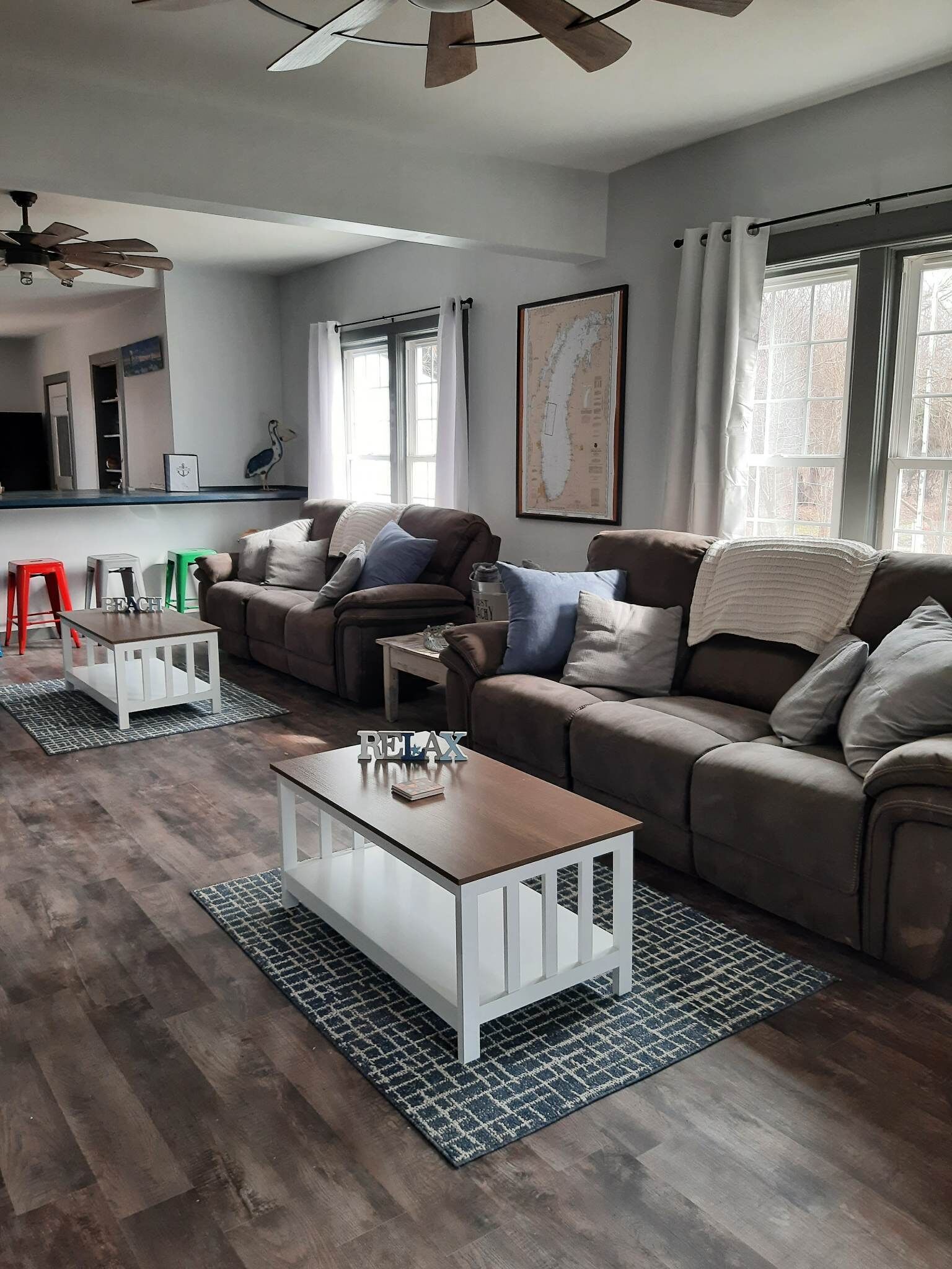 A modern living room with a sectional sofa, a coffee table, and a dining area with a counter.