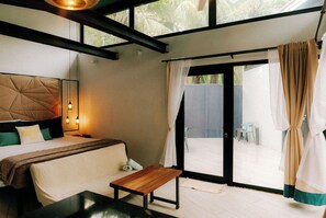 A bedroom with a bed, bedside table, and a view of the outside. - ALL-INCLUSIVE option- 9 casitas up to 30 pax (playa potrero)