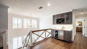 Eine geräumige Küche mit Holzböden, einer Treppe und Blick ins Freie.