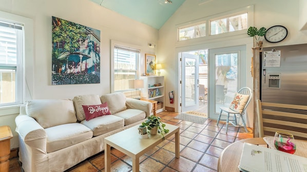 Una sala de estar con un sofá color beige, una mesa de centro y un cuadro en la pared.
