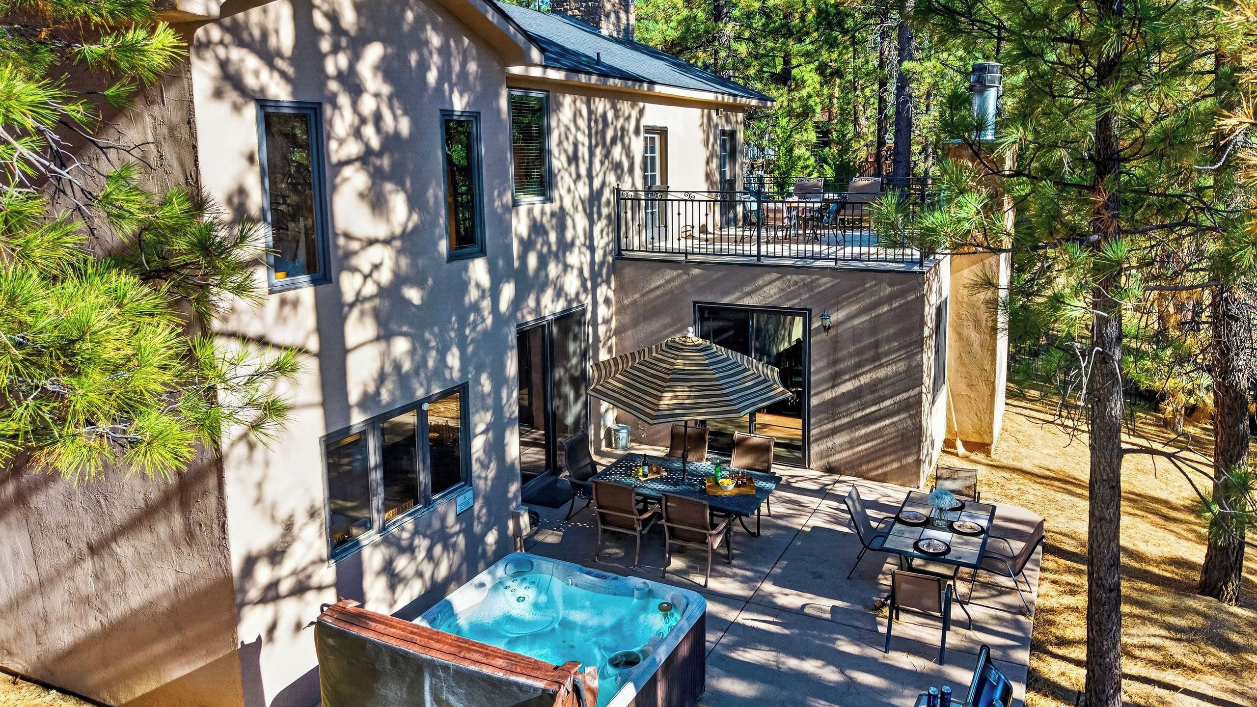 A two-story house with a swimming pool, outdoor dining area, and a covered patio.