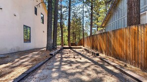 A narrow alley with a wooden fence on one side and a building on the other. - Walk to Lake 6BR Cabin w/ Game Room, Hot Tub Big Bear Castle (Big Bear Lake)