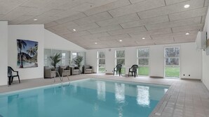 An indoor swimming pool with clear glass walls, a tiled ceiling, and a view of the outdoors. - Amazing home in Hals with kitchen (Hals)