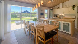 A modern kitchen with a dining area, large windows, and a view of the outdoors. - Amazing home in Hals with kitchen (Hals)